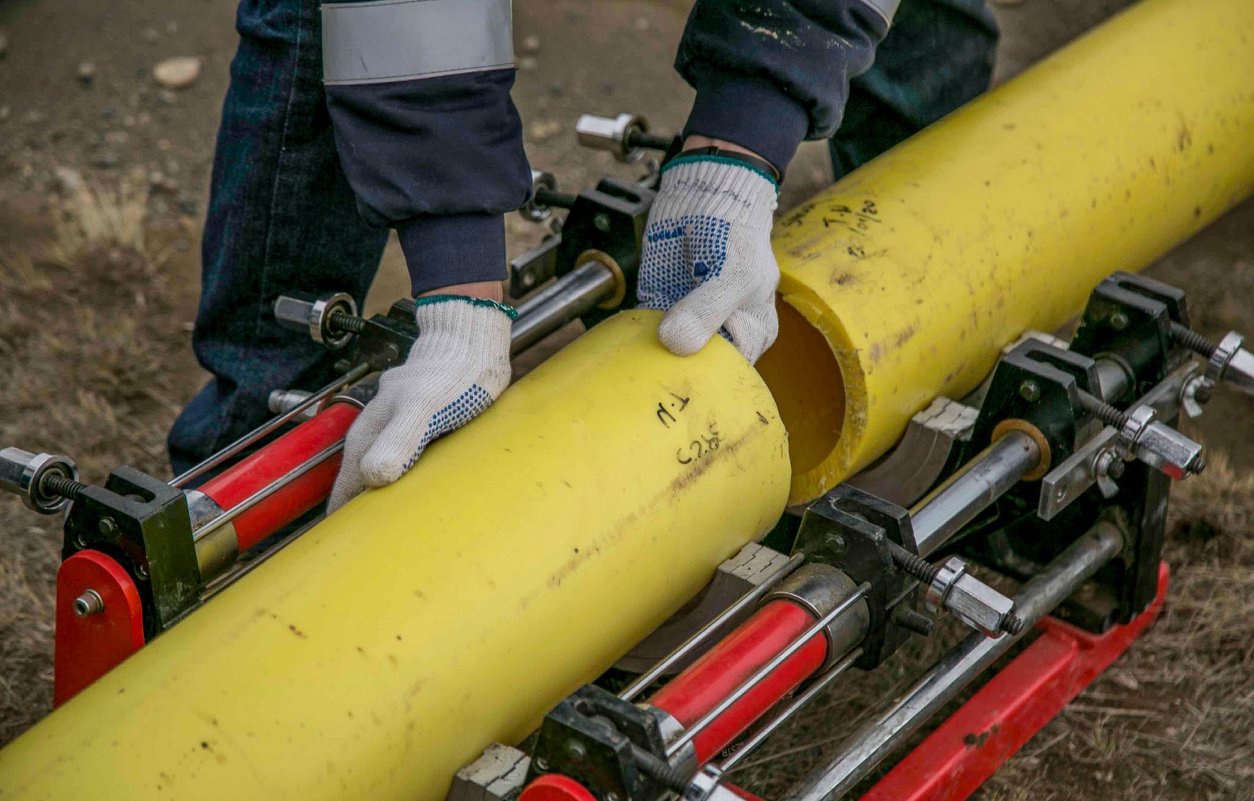 Handwerker verlegt und verpresst eine Gasrohrleitung mit Präzisionswerkzeug